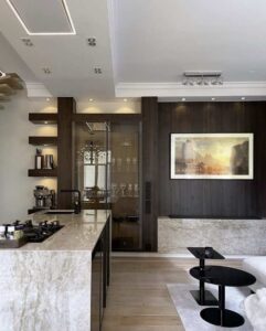 Träkök i valnötsfärg och stor köksö med vitrinskåp och keramisksten från dekton.