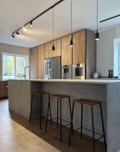 Platsbyggt kök i Stockholm med träköksluckor och måttanpassad köksö. Bänkskiva i grå granitliknande keramisksten dekton