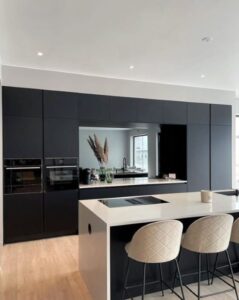 Platsbyggt kök med svarta fenix laminat luckor och bänkskiva i vit kompositsten Silestone