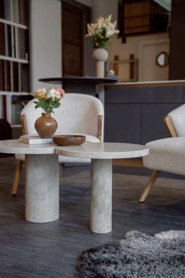 Miljöbild från showroom med platsbyggt kök i bakgrunden pch fåtöljer med designat stenbord i fokus.
