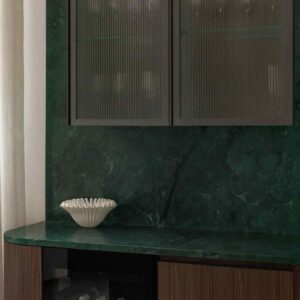 Modern kök i en lägenhet. med rundade hörn i träluckor. Bänkskiva och stänkskydd i marmor