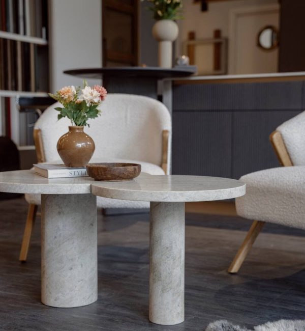 Miljöbild från showroom med platsbyggt kök i bakgrunden pch fåtöljer med designat stenbord i fokus.