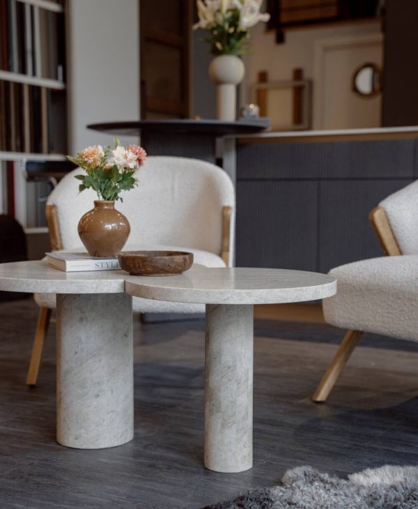 Miljöbild från showroom med platsbyggt kök i bakgrunden pch fåtöljer med designat stenbord i fokus.