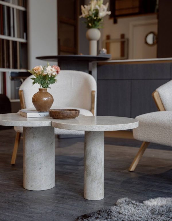 Miljöbild från showroom med platsbyggt kök i bakgrunden pch fåtöljer med designat stenbord i fokus.